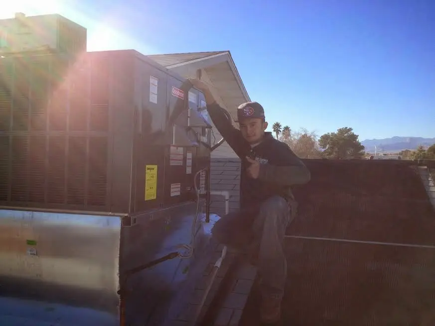 HVAC technician performing Heat Pump Repair on a rooftop unit in Greenbrier